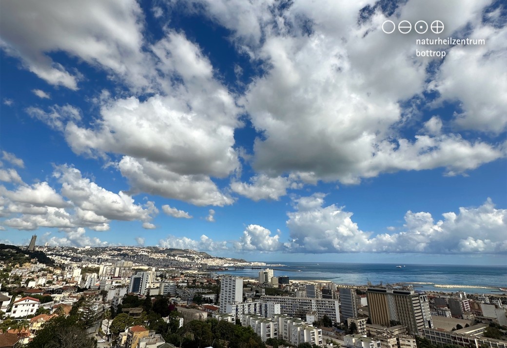 Eine sommerliche Stadtkulisse am Meer mit beeindruckenden Wolkenformationen