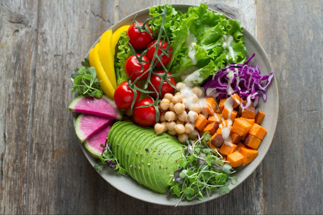 Colorful raw vegetable plate with avocado, tomatoes and lettuce 