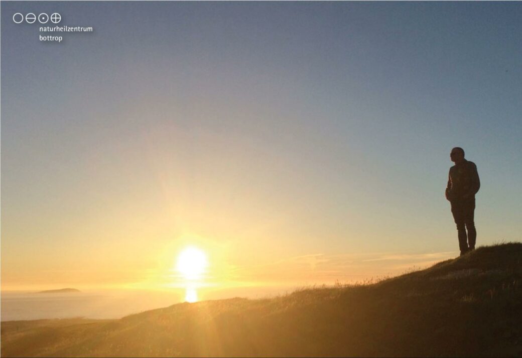 Homme à contre-jour devant un coucher de soleil