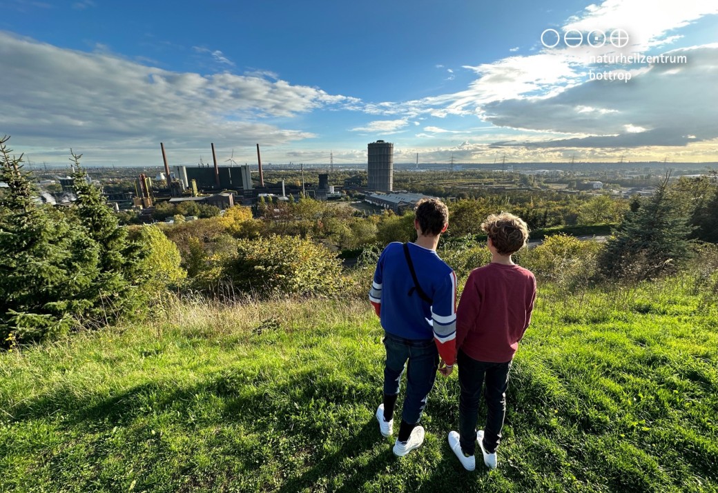 Zwei Jungen schauen von einem erhöhten Aussichtspunkt auf eine Stadt
