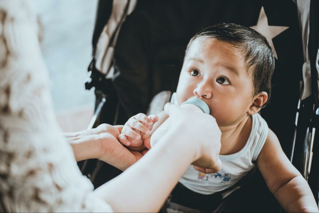 Baby in stroller being fed